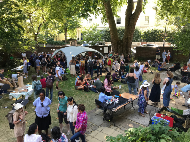 People gathered outdoors with a white gazebo