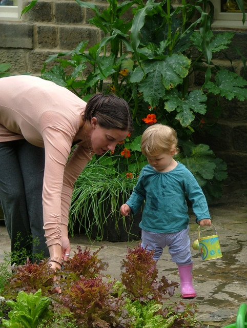 Mum and baby watering plants