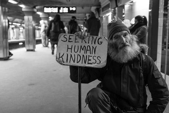 homeless man holding a sign