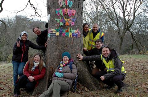 A group of Permaculture Association members at a local gathering in Sunderland. The tree is decorated by participants, with 'Fair Share. Future generations'