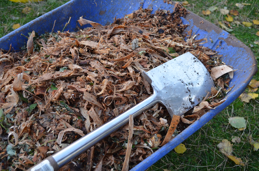 Wheelbarrow with mulch and spade