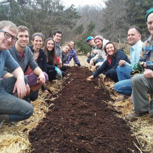 Group of students standing over newly sheet mulched garden bed