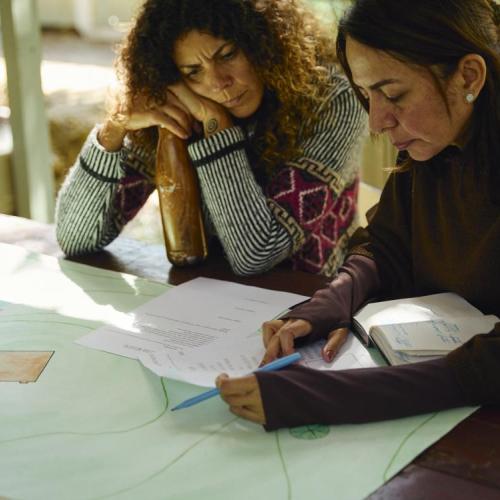 Two students sitting around a table in front of a map of the land