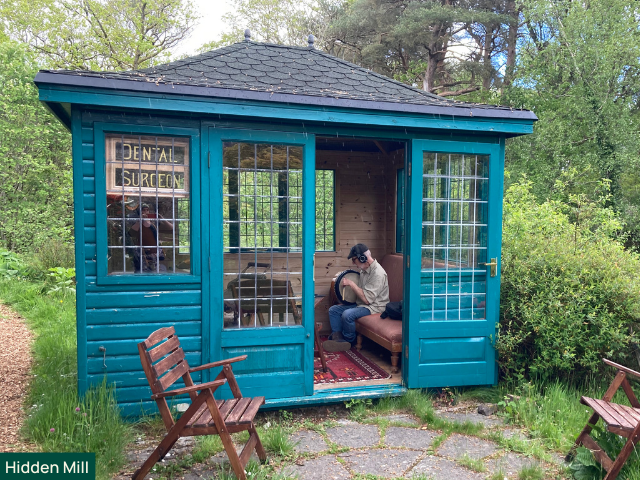 man playing banjo in a shed at hiddern mill